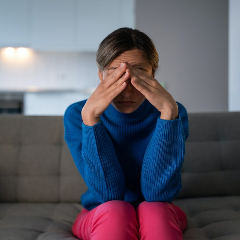 Pensive woman sitting on sofa has depression and melancholy after breaking up with boyfriend